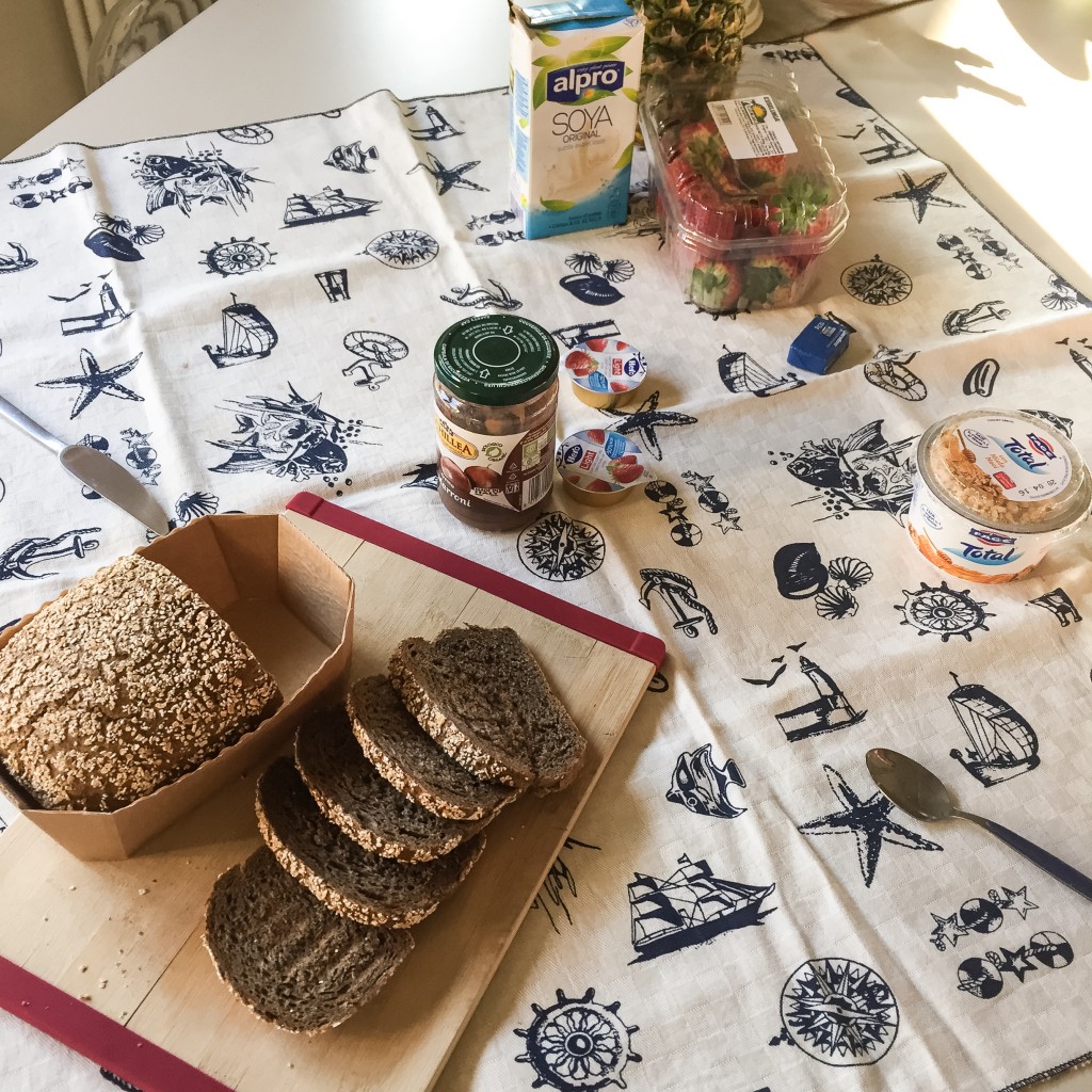 Colazione della domenica: pane di grano duro; marmellata di fragole; yogurt greco Fage; frutta fresca; latte di soia Alphro